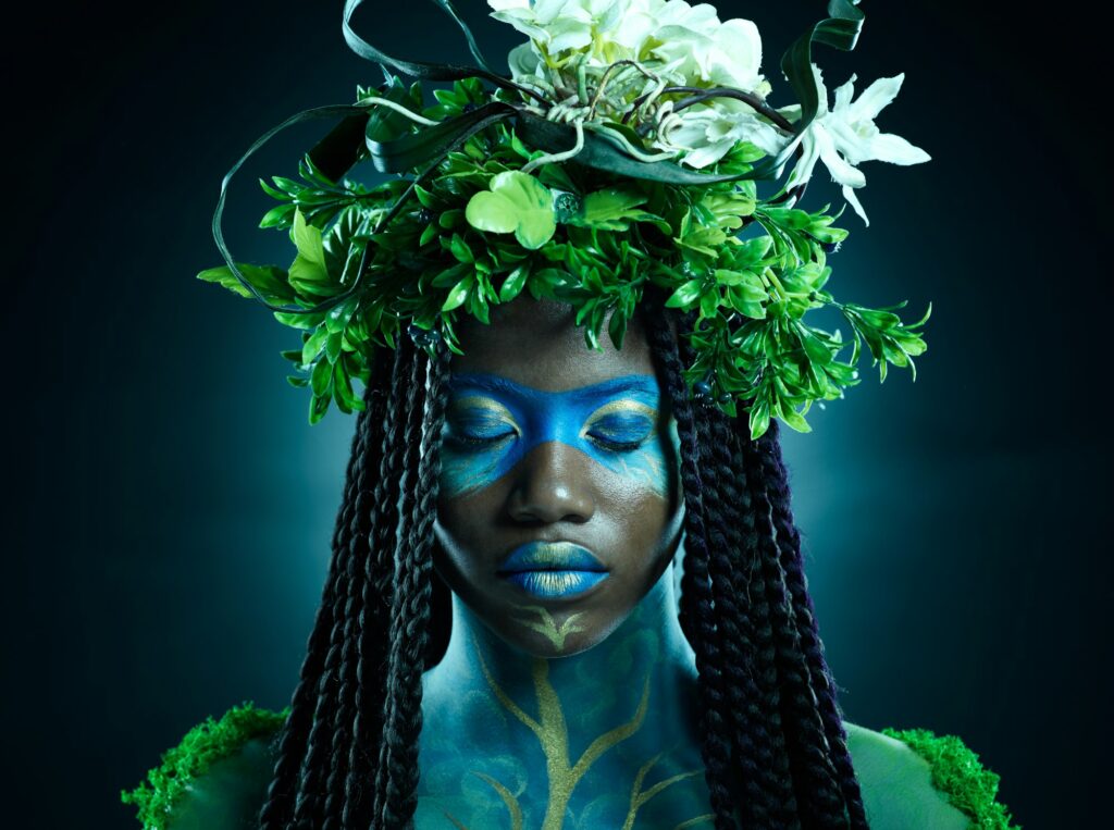 Black woman, plant crown and beauty of face with makeup on dark background with tropical leafs. Fai